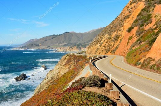 Car on a coastal road with cliffs and blue sea