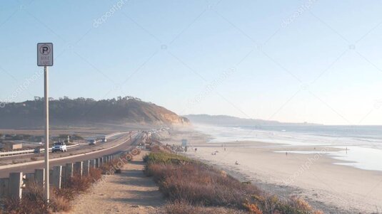 Car driving along a highway beside the Pacific coast